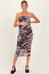 woman wearing a strapless maternity dress with a floral print and holding her baby bump