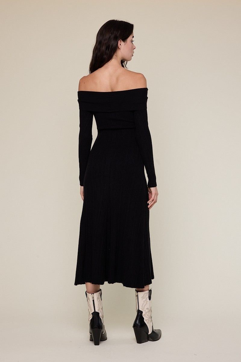 woman wearing a black off-shoulder ribbed midi dress with long sleeves and paired with black and white cowboy boots