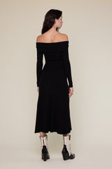 woman wearing a black off-shoulder ribbed midi dress with long sleeves and paired with black and white cowboy boots