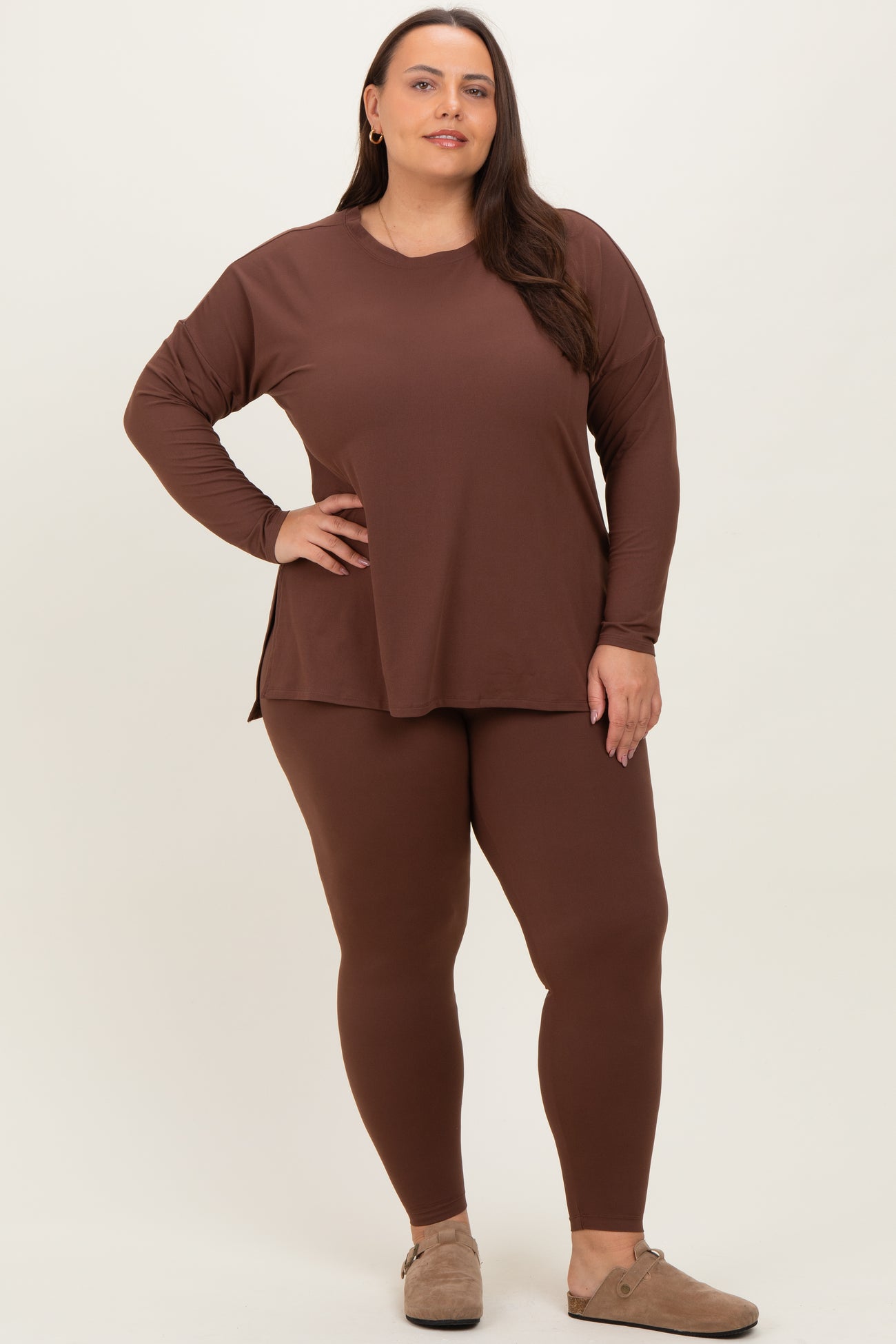 woman wearing a brown long sleeve top and matching leggings, styled for a comfortable look