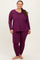 woman wearing a purple long sleeve top and matching leggings in plus size, standing with a smile