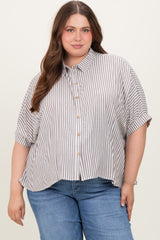 woman wearing a striped short sleeve button-up maternity plus top with a relaxed fit and roll-up sleeves