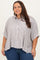 woman wearing a beige and white striped plus size button-up shirt with rolled sleeves and high-low hem