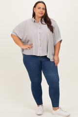 woman wearing a striped oversized button-up shirt with a relaxed fit and paired with skinny jeans and white sneakers