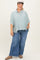 woman wearing a striped maternity plus button-up shirt with loose fit and wide-leg jeans, smiling and posing