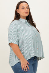 plus size woman wearing a green and white striped button-up shirt with short sleeves and a side slit, paired with blue jeans
