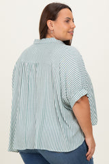 plus size woman wearing a light green and white striped oversized shirt with a back pleat and rolled sleeves