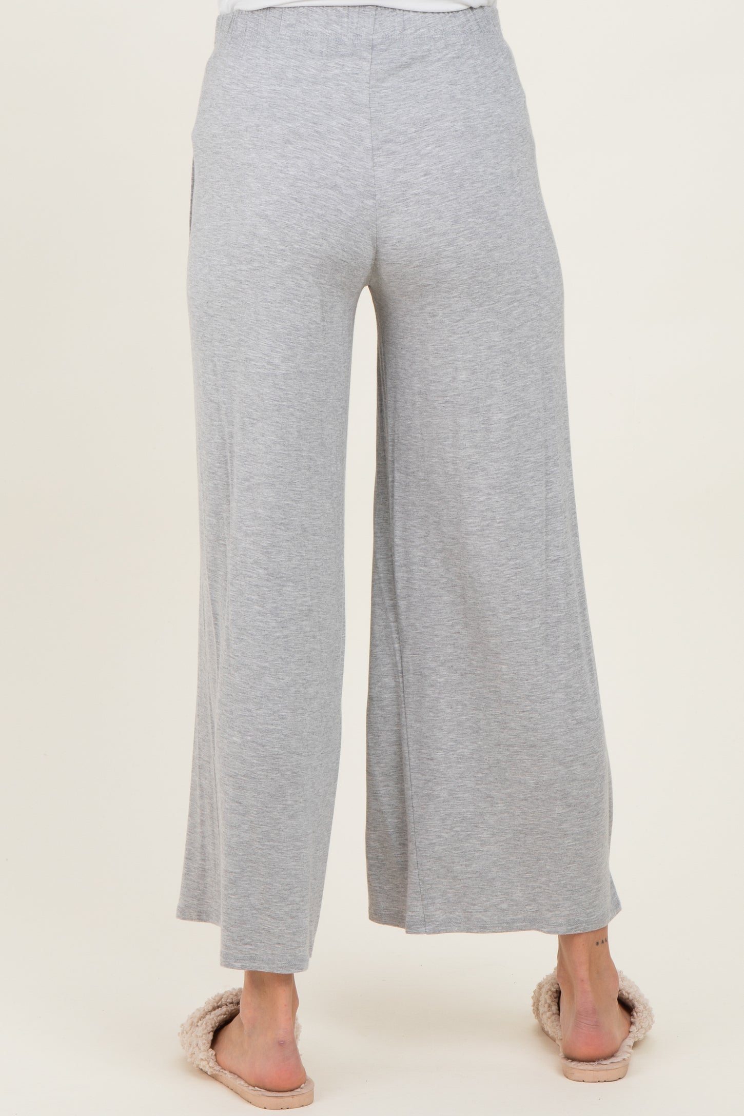 woman wearing light gray wide-leg maternity pants, shown from the back