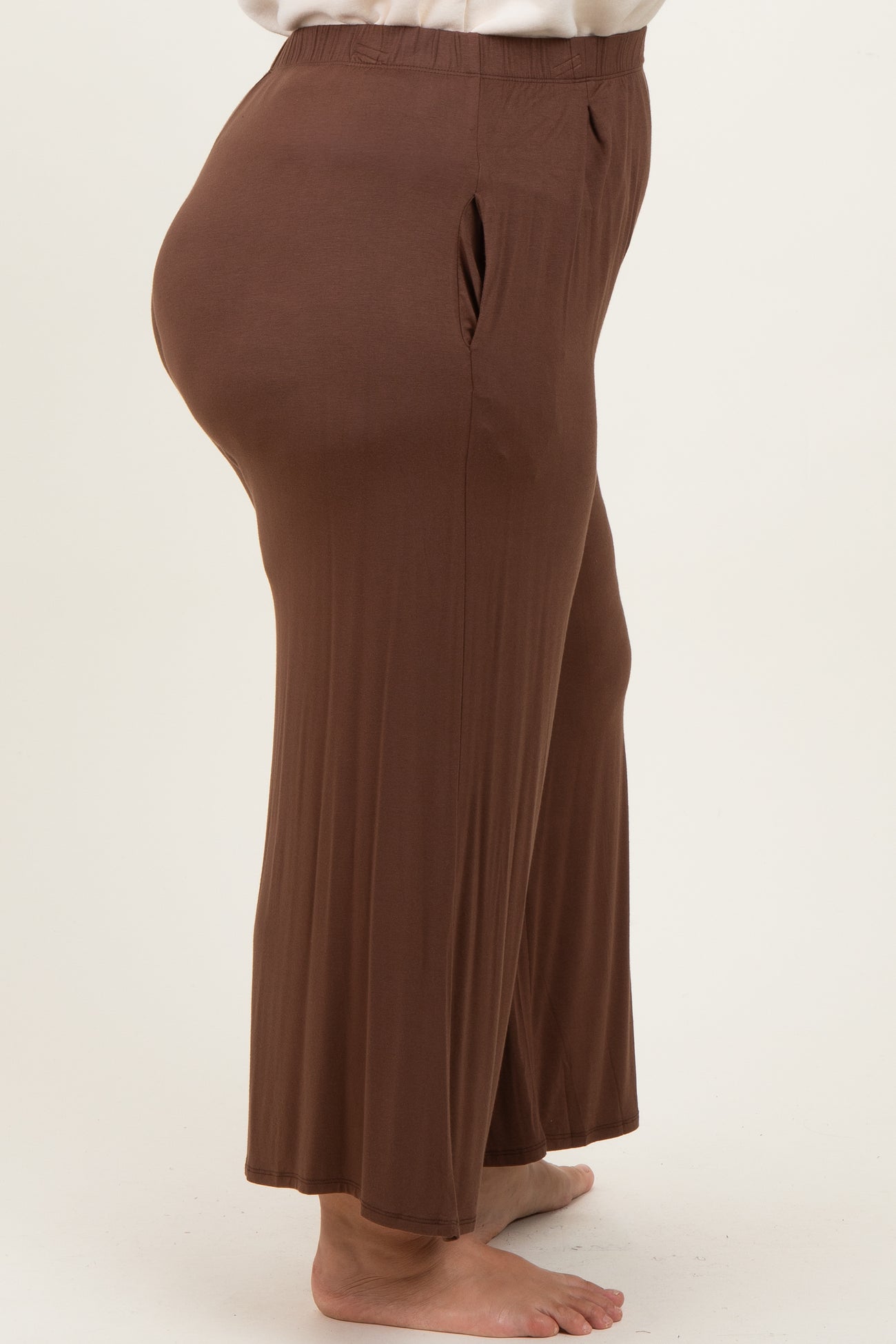 woman wearing brown plus-size lounge pants with a relaxed fit and side pockets