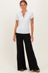 woman wearing a gray short sleeve henley top and black wide-leg pants