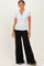 woman wearing a gray short sleeve henley top and black wide-leg pants