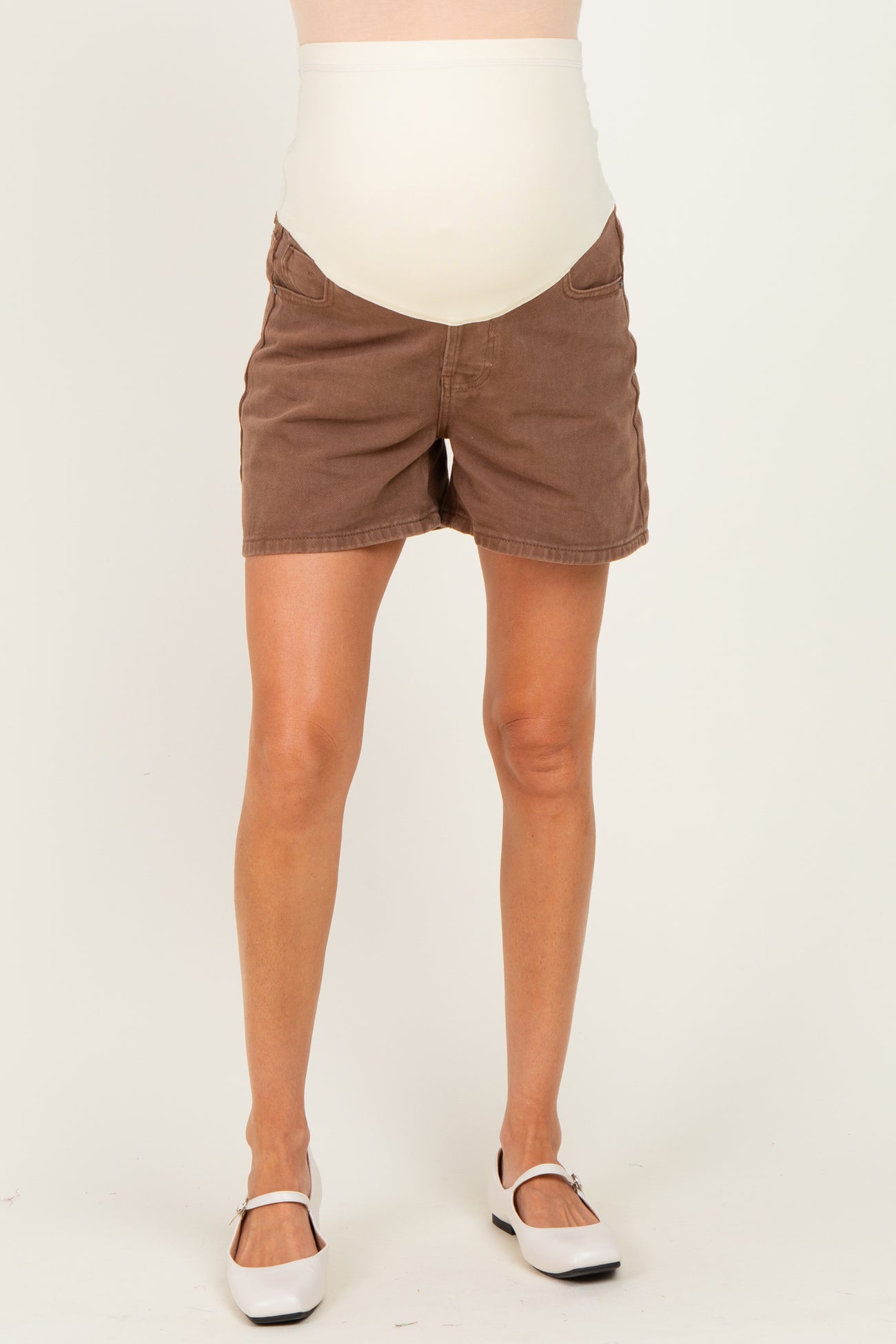 woman wearing brown maternity shorts with a cream-colored over-the-bump waistband