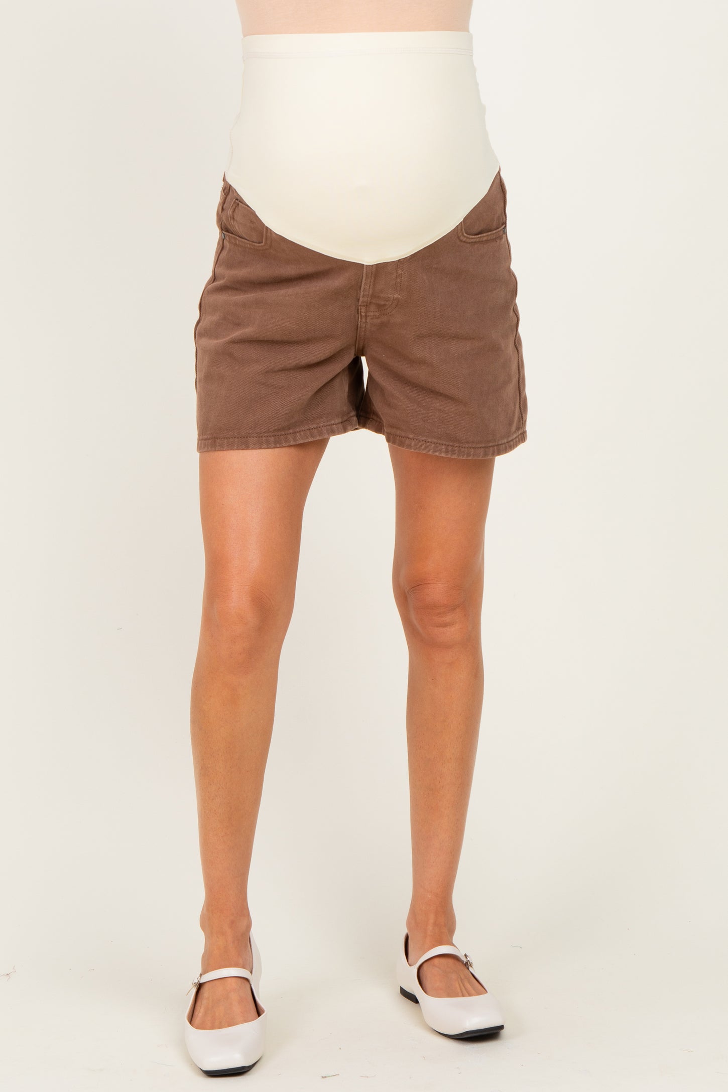 woman wearing brown maternity shorts with a cream-colored over-the-bump waistband