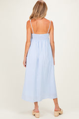 woman wearing a light blue striped maternity maxi dress with spaghetti straps and a smocked back, seen from the back