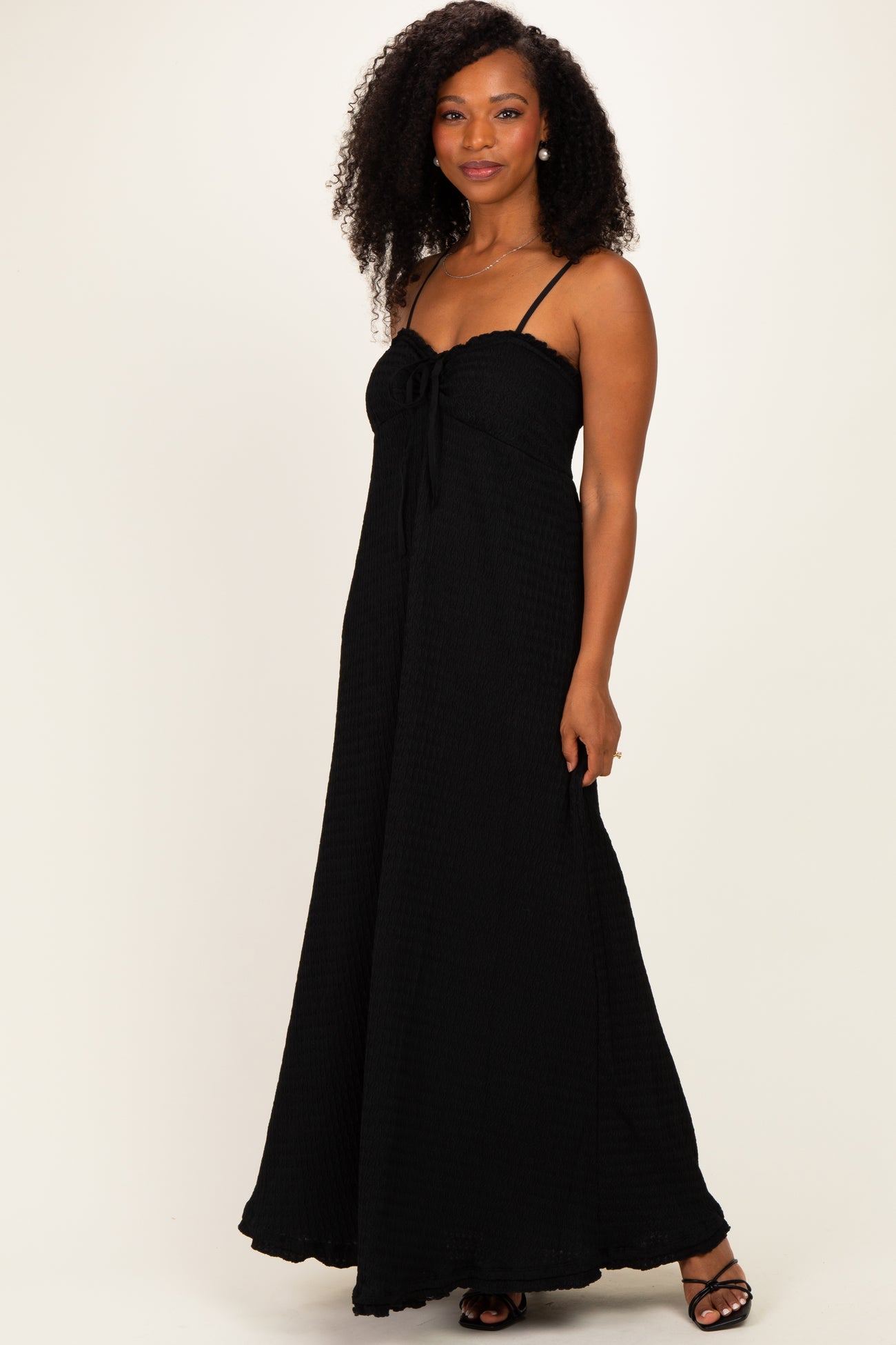 woman wearing a black maxi dress with a tie front and spaghetti straps