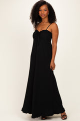 woman wearing a black maxi dress with a tie front and spaghetti straps