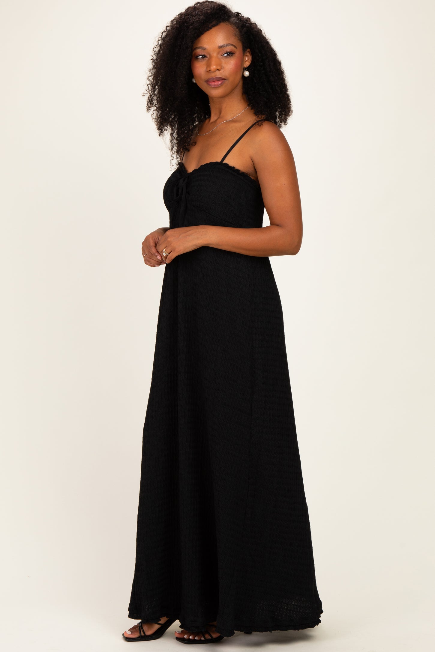 woman wearing a black long maxi dress with spaghetti straps and a tie front detail