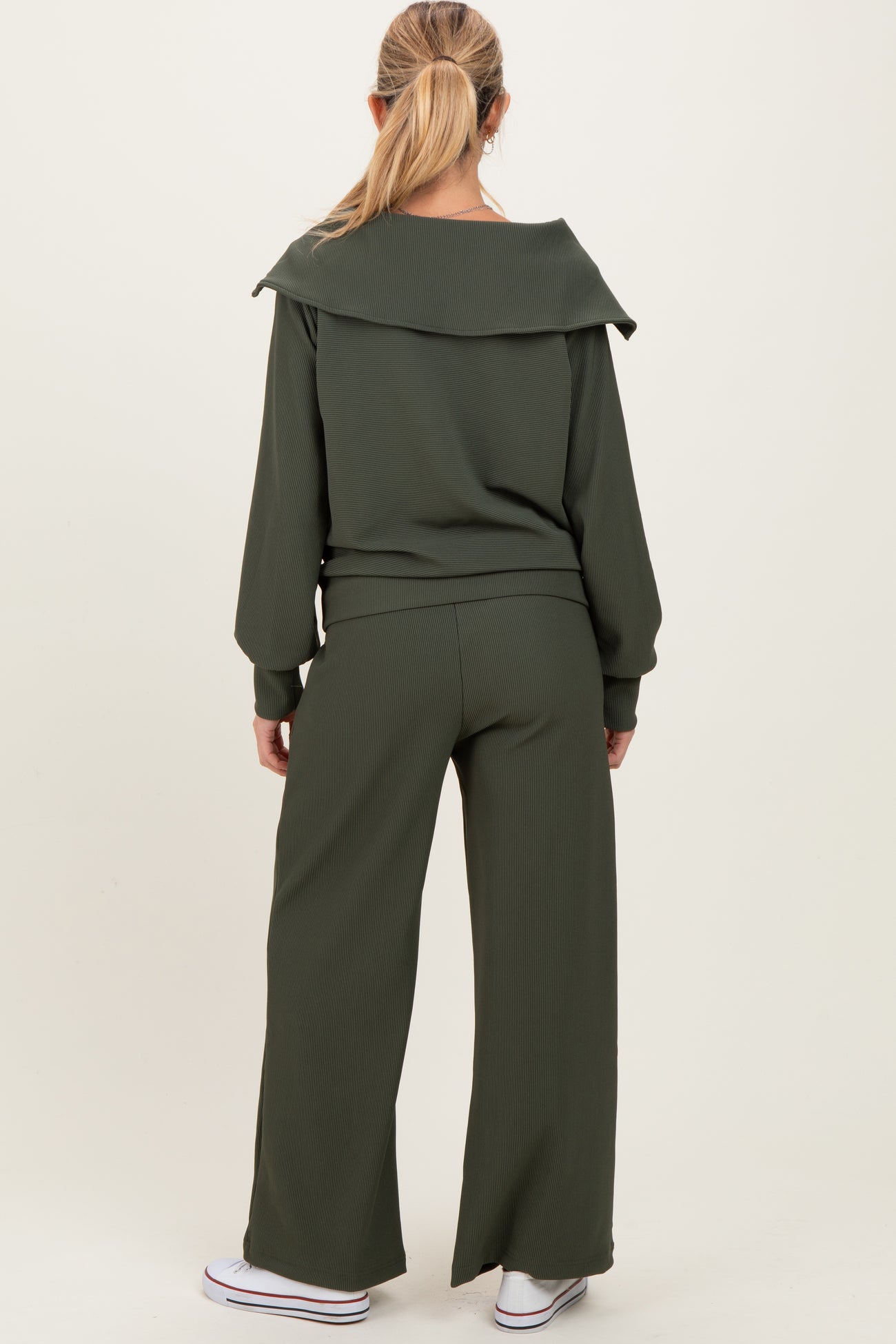 woman wearing a ribbed dark green maternity lounge set with a relaxed fit and wide-leg pants, viewed from the back