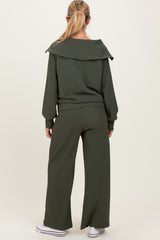 woman wearing a ribbed dark green maternity lounge set with a relaxed fit and wide-leg pants, viewed from the back
