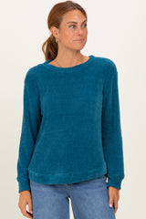 woman wearing a teal long sleeve waffle knit sweater with a relaxed fit and round neckline