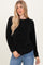 woman wearing a black ribbed long sleeve sweater and blue jeans