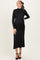 woman wearing a black long sleeve maternity dress with side ruching and a high neckline, showcasing her baby bump