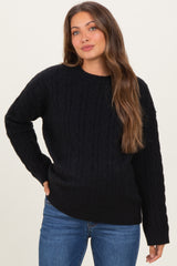 woman wearing a black cable knit maternity sweater with long sleeves and relaxed fit