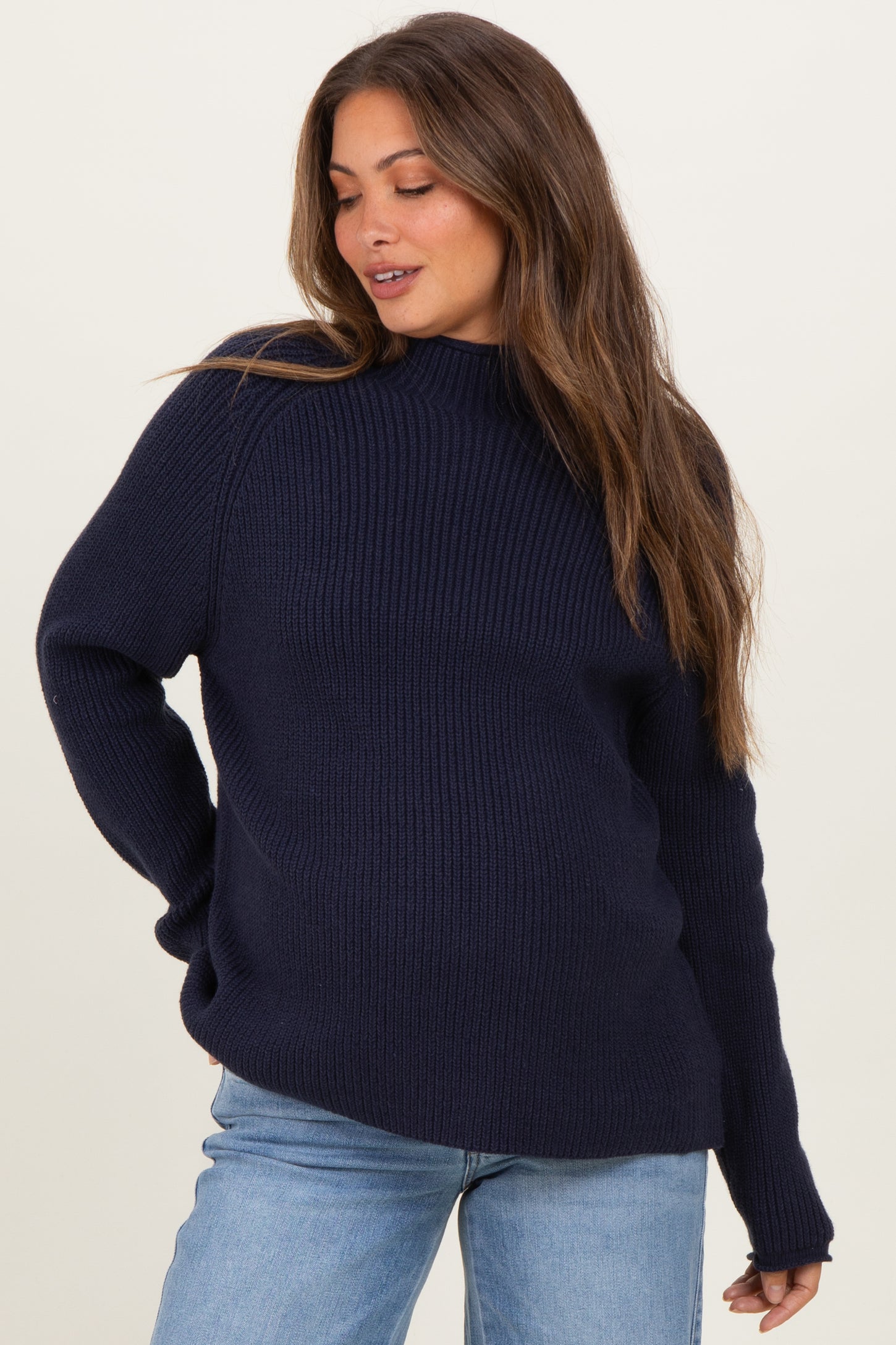 woman wearing a navy blue ribbed maternity sweater with a relaxed fit and visible baby bump