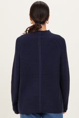 woman wearing a navy blue oversized ribbed sweater, showing the back view with a relaxed fit and dropped shoulders