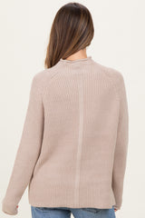 woman wearing a beige ribbed maternity sweater, view from the back