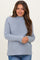 woman wearing a light blue maternity sweater with a ribbed texture and long sleeves