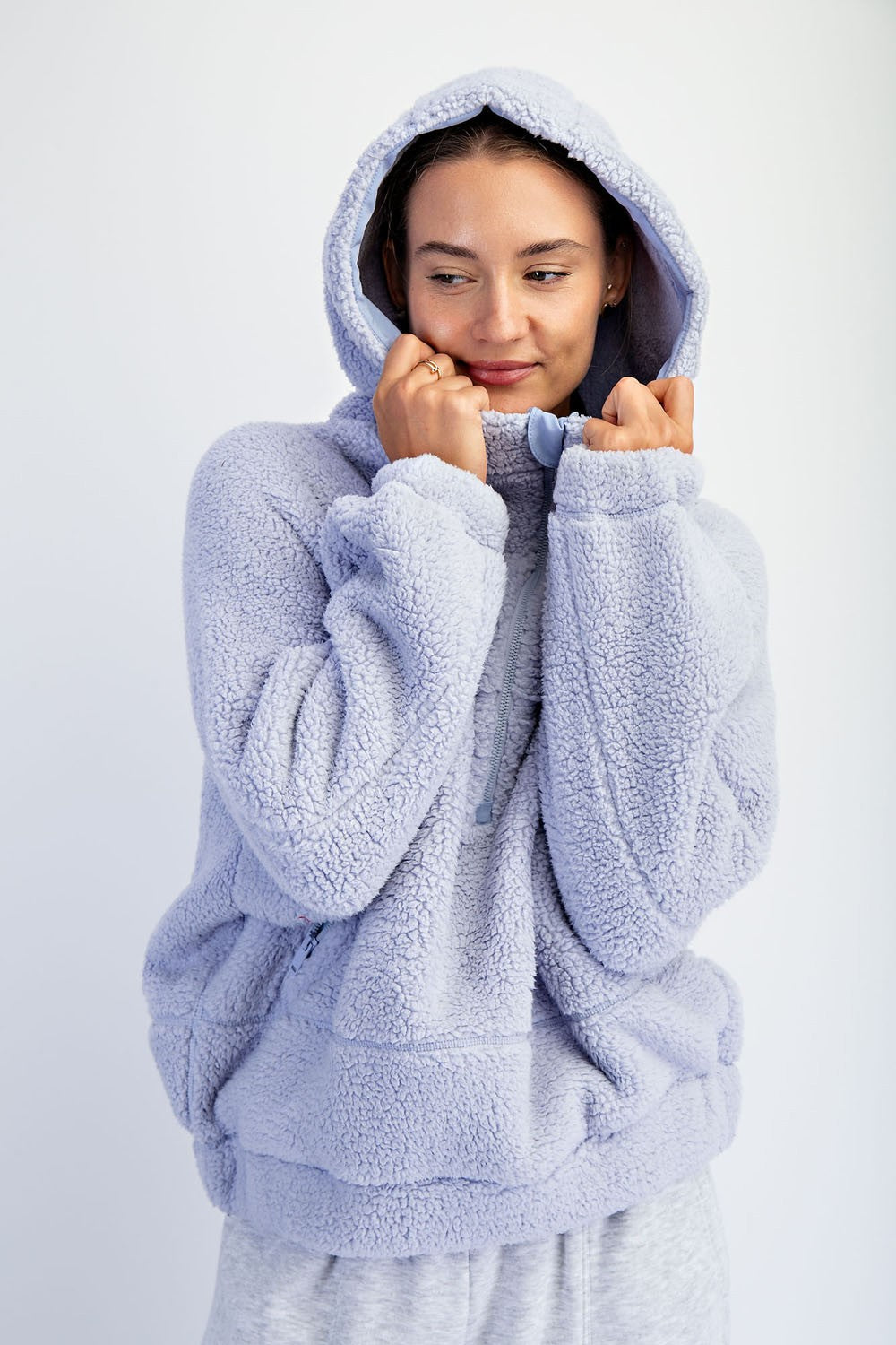 woman wearing a light purple fleece pullover hoodie with a relaxed fit and a zipper detail near the collar