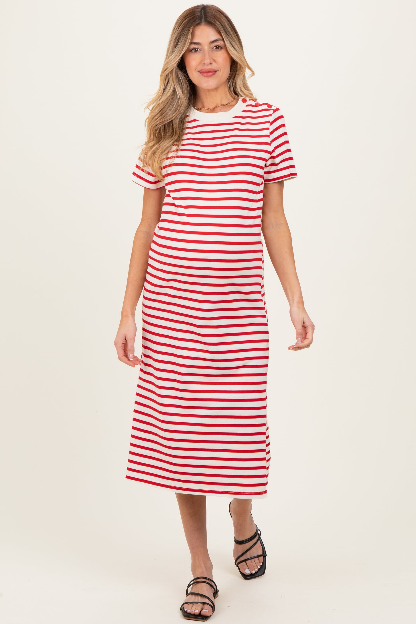 woman wearing a red and white striped maternity dress with short sleeves and a midi length, showcasing a baby bump