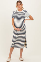 woman wearing a navy and white striped maternity dress with a side slit and holding her baby bump