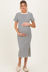 woman wearing a navy and white striped maternity dress with a side slit and holding her baby bump