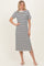 woman wearing a black and white striped midi dress with short sleeves and side slits