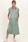 woman wearing a sage green maternity dress with a collared neckline and side pockets, featuring a relaxed fit and slit details