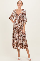 woman wearing a floral print maternity dress with a v-neckline and puff sleeves, displaying a baby bump