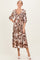 woman wearing a floral print maternity dress with a v-neckline and puff sleeves, displaying a baby bump