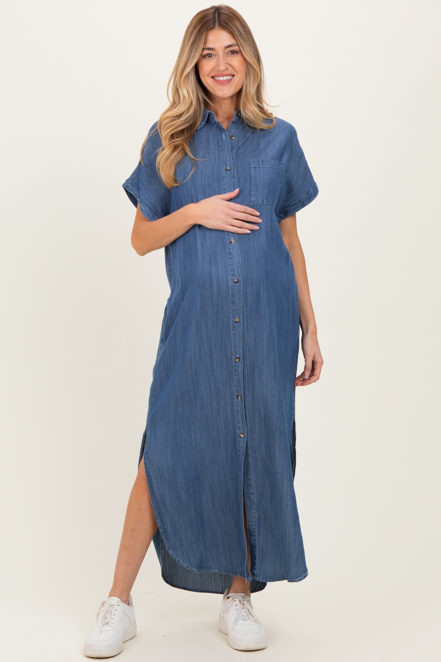 woman wearing a denim maxi shirt dress, featuring short sleeves and side slits, highlighting her baby bump