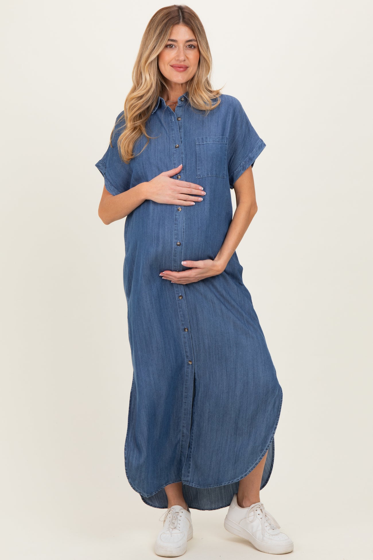 woman wearing a blue denim maxi maternity dress with short sleeves and a baby bump