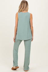 woman wearing a light green maternity loungewear set with a sleeveless top and wide-leg pants
