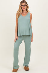 woman wearing a light green maternity sleeveless top and matching pants, with a visible baby bump