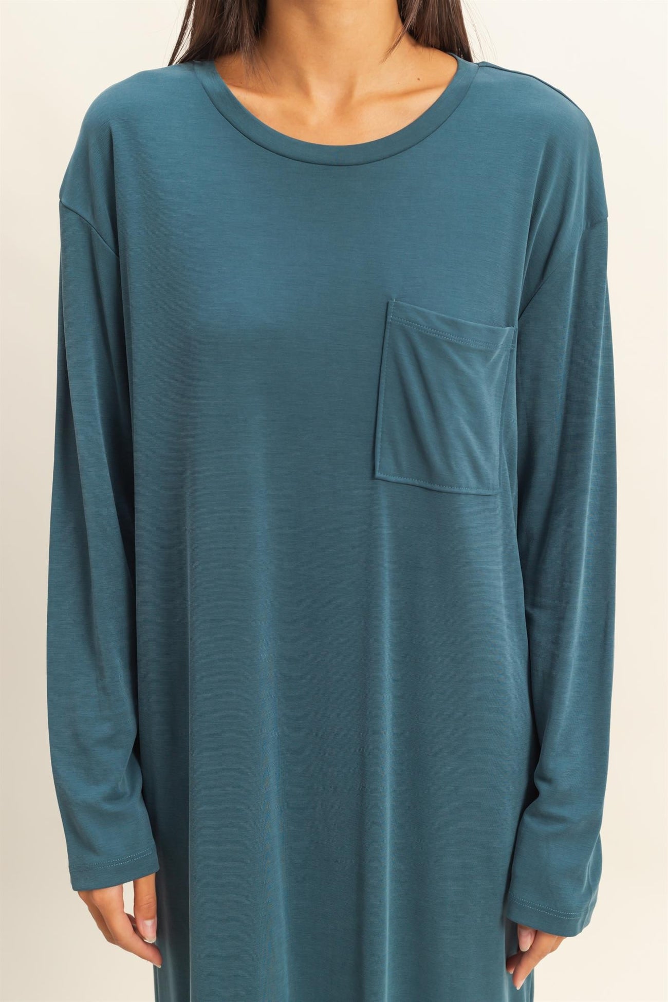 woman wearing a teal long sleeve dress with a chest pocket and relaxed fit