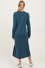 woman wearing a dark teal long sleeve maternity dress with side slits, viewed from the back