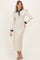 woman wearing an ivory long sleeve maxi dress with a navy collar and button placket, styled with nude heeled sandals