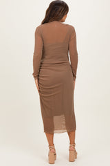 woman wearing a brown long sleeve maternity dress with a fitted silhouette and side ruching detailing.