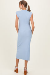 woman wearing a light blue ribbed maternity dress with cap sleeves and a midi length, showing a smooth back silhouette