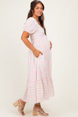 woman wearing a striped maternity dress with puff sleeves and pockets, showing her baby bump