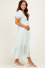 woman wearing a striped maternity dress with puff sleeves, mid-length, holding her baby bump